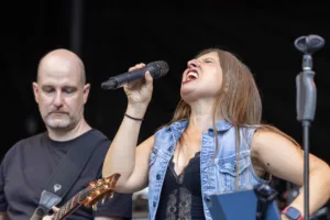 Sängerin Maren Disch singt mit zurückgelegtem Kopf, während Gitarrist Alexander Stocker hinter ihr spielt.