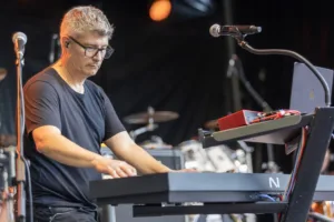 Keyboarder Ralf Rees spielt konzentriert an zwei übereinander angeordneten Keyboards auf der offenen Bühne.