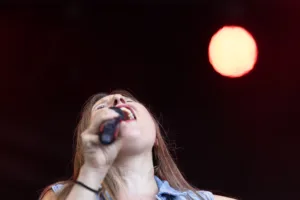 Sängerin Maren Disch singt mit zurückgelegtem Kopf ins Handmikrofon, über ihr leuchtet ein runder Scheinwerfer.