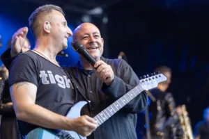 Gitarrist Sascha Happle und Sänger Sascha Spitz stehen Schulter an Schulter am Bühnenrand und wenden sich gemeinsam dem Publikum zu.