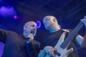 Sänger Sascha Spitz singt dicht neben Bassist Steffen Vogt, der seinen Bass unter violett-blauem Licht spielt.