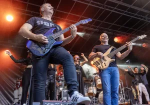 Gitarrist Sascha Happle und Bassist Steffen Vogt spielen nebeneinander am Bühnenrand, unmittelbar vor den erhobenen Händen des Publikums.